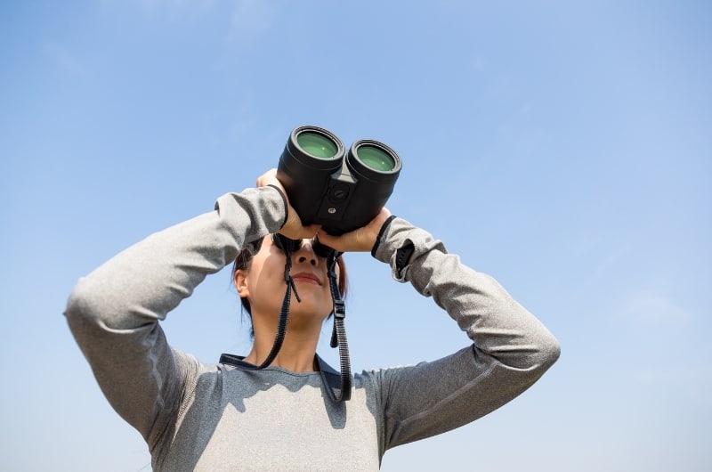 a woman looking though binoculars