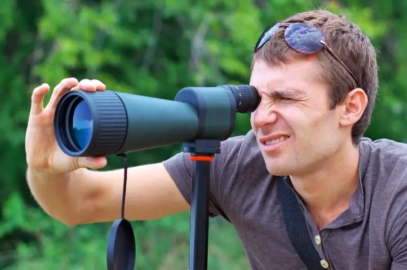 a man using a spotting scope for bird watching