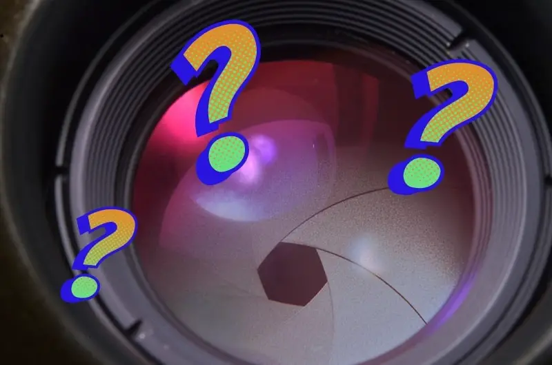 a close up of a camera lens showing the aperture blades and three question mark graphics positioned above it