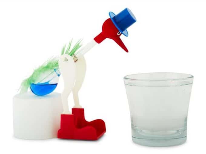 a drinking bird ornament beside a glass of water cute bird gifts