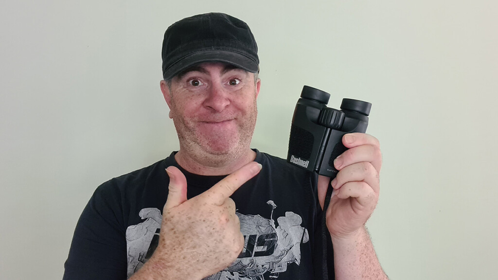 Barry Callister from Birdwatch World holding a pair of Bushnell 8x24 binoculars