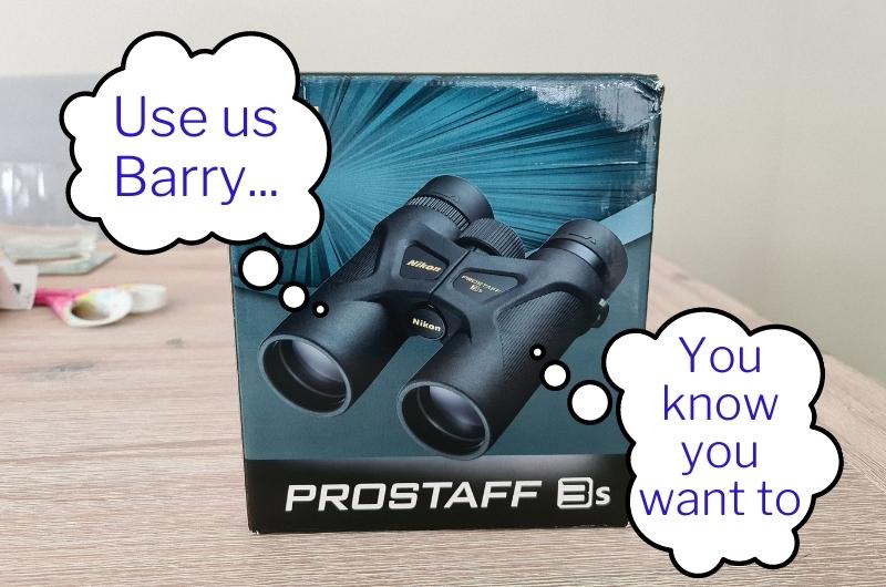a box containing Nikon Prostaff 3S binoculars with thought bubbles coming out of it reading 'use us Barry' and 'You know you want to'