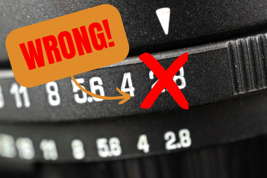 A close up of a camera aperture ring set at 2.8. A red cross is over the 2.8 number. To the left of the red cross is a curved orange arrow and a rounded orange rectangle with the world wrong in bold red text inside it.