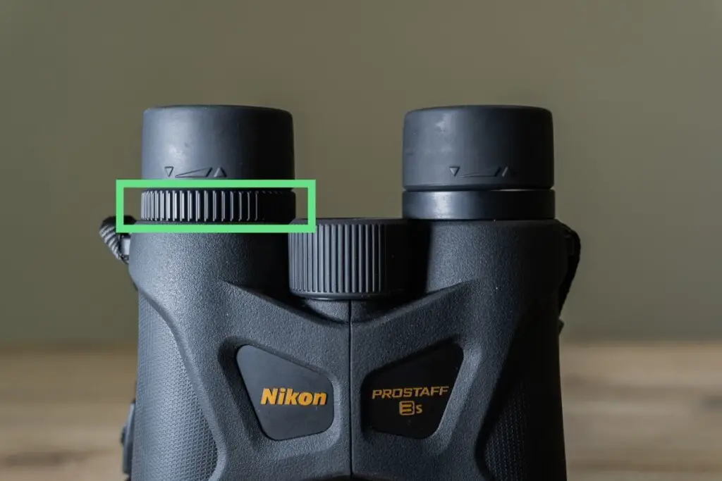 a pair of nikon prostaff 3S binoculars showing the diopter dial outlined in green