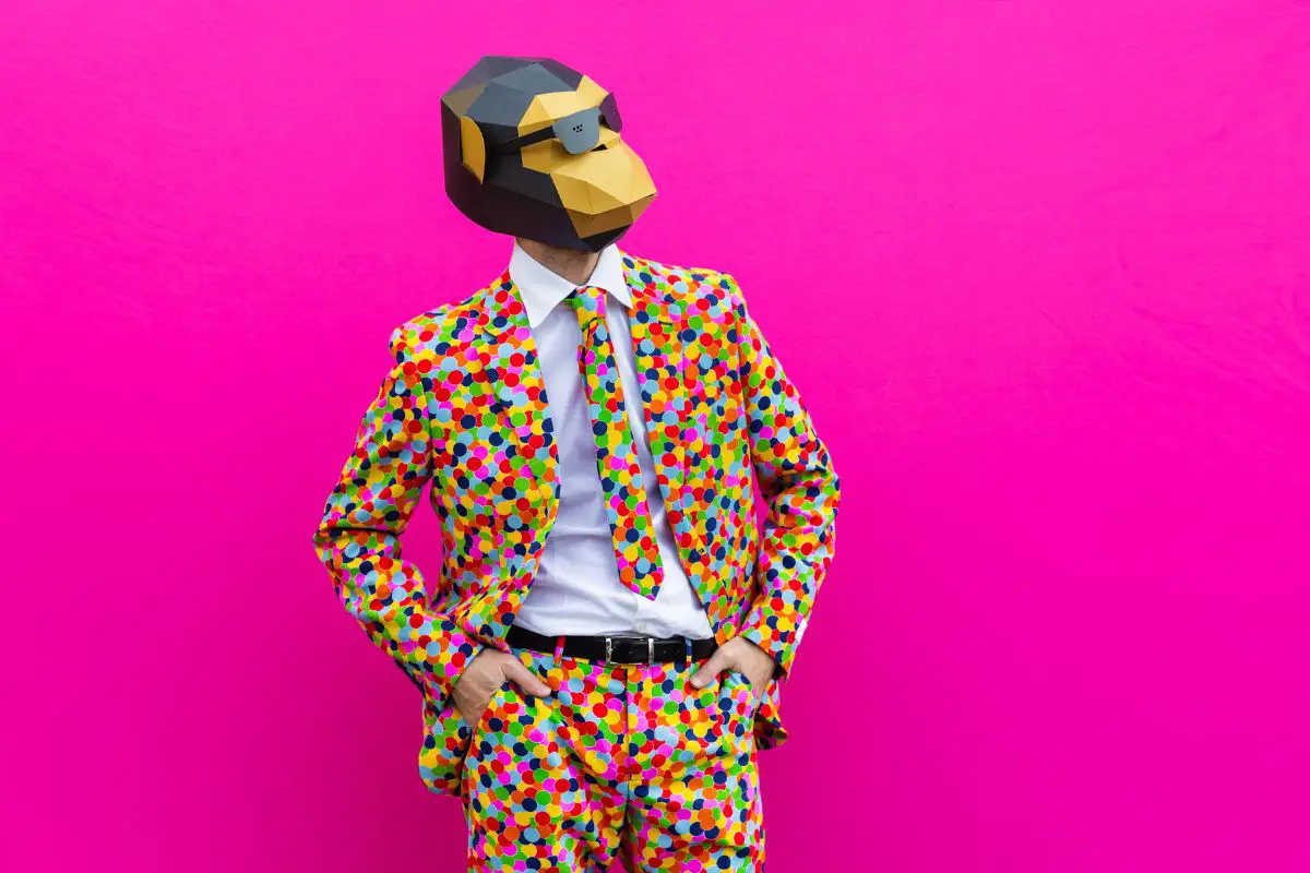 a man wearing a colorful suit and tie and a money mask against a bright pink background
