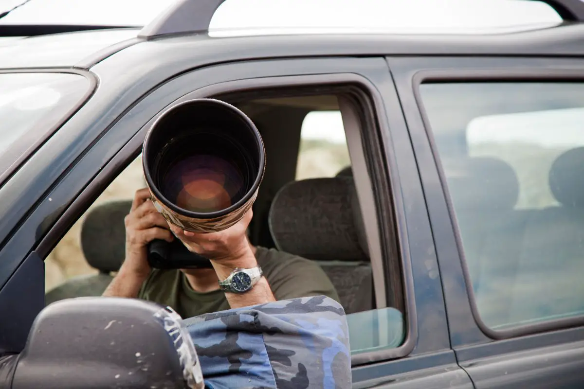 a male photographer shooting from his car window