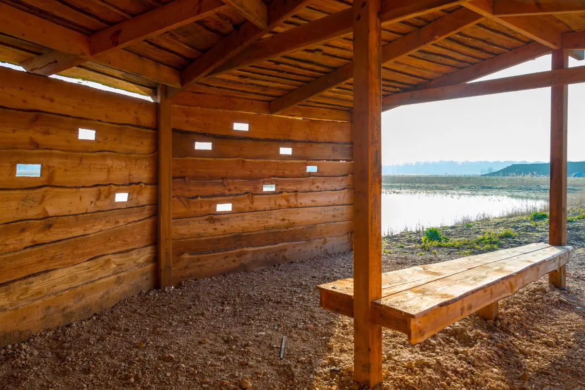 a timber bird blind beside a wetland