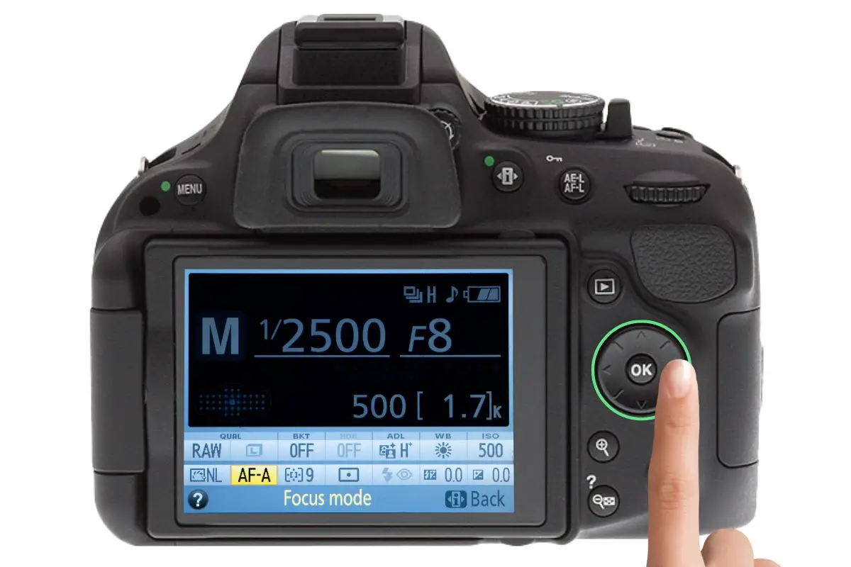 the rear of a Nikon D5200 showing the information display. A woman's hand is pressing the selector switch