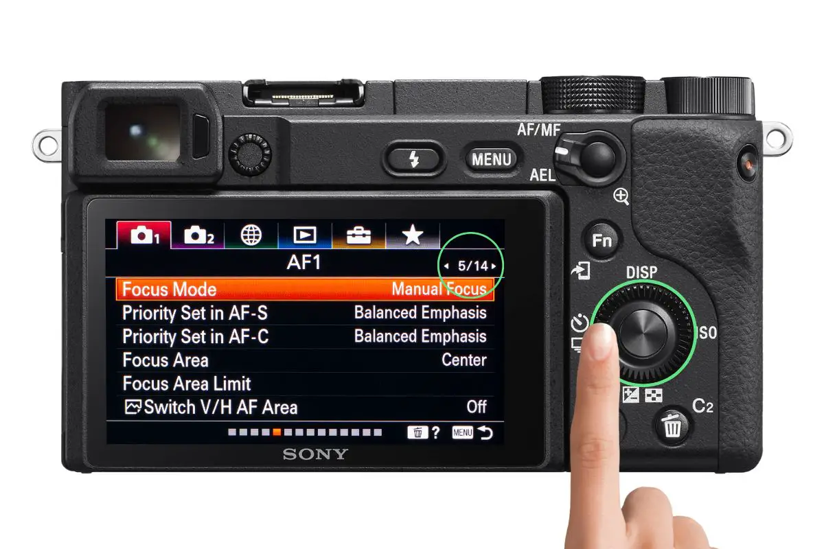 the rear of a Sony a6400 camera showing the AF1 menu screen with a woman's hand pressing the control wheel