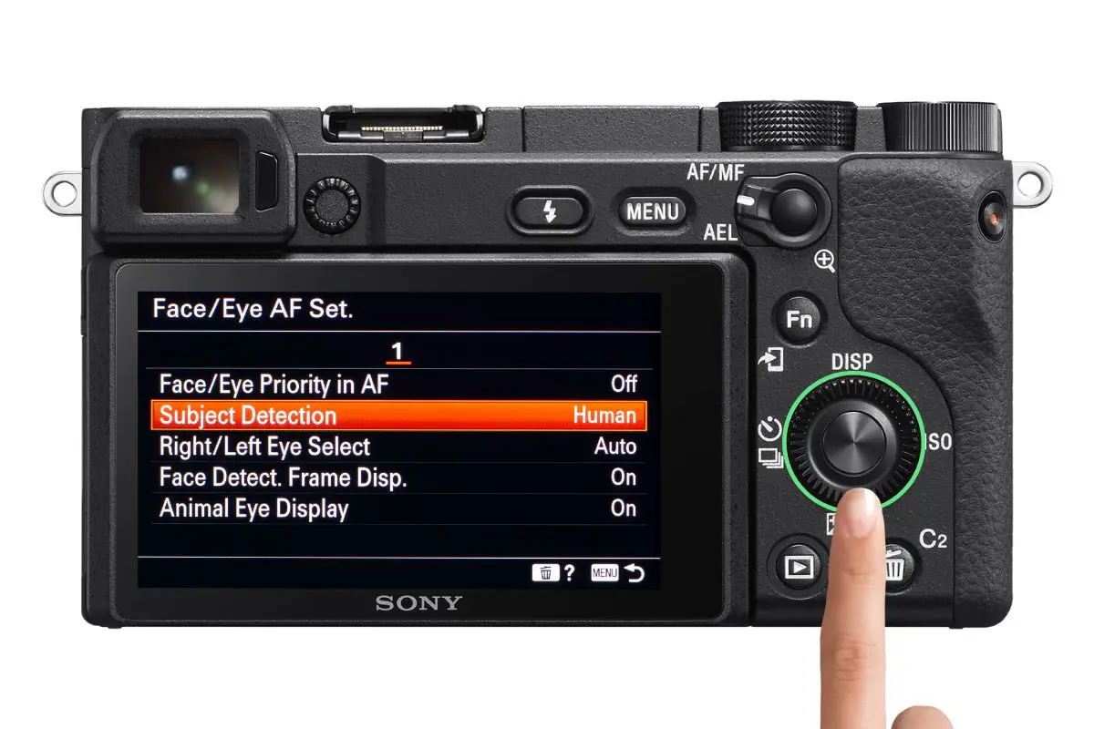 the rear of a Sony a6400 camera showing the Face/Eye AF Set. screen with a woman's hand pressing the control wheel