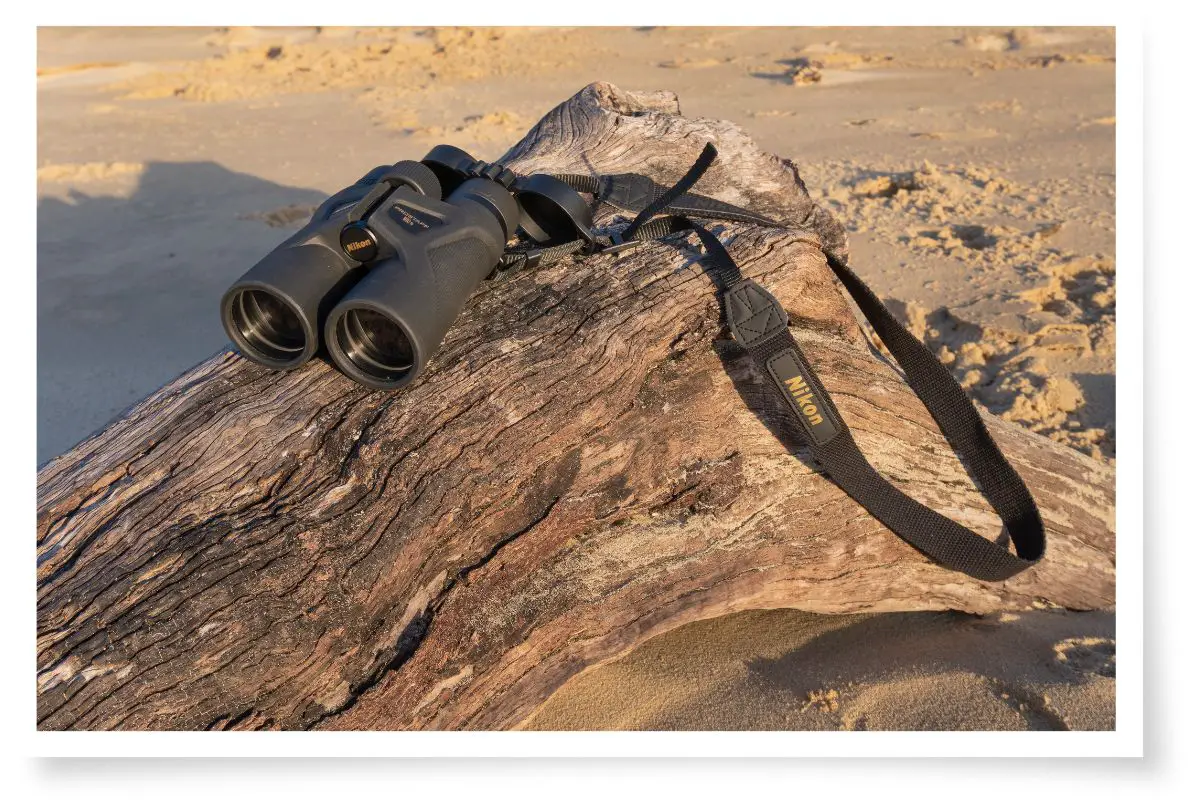Nikon Prostaff 3S binoculars laying on a log at the beach